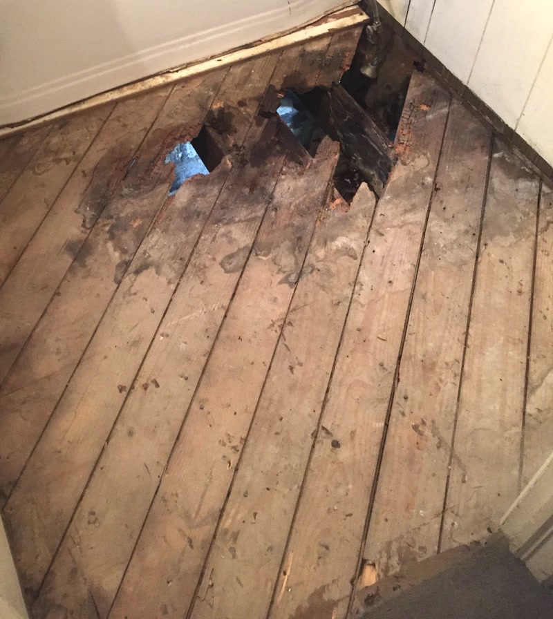 Damaged bathroom subfloor before renovation