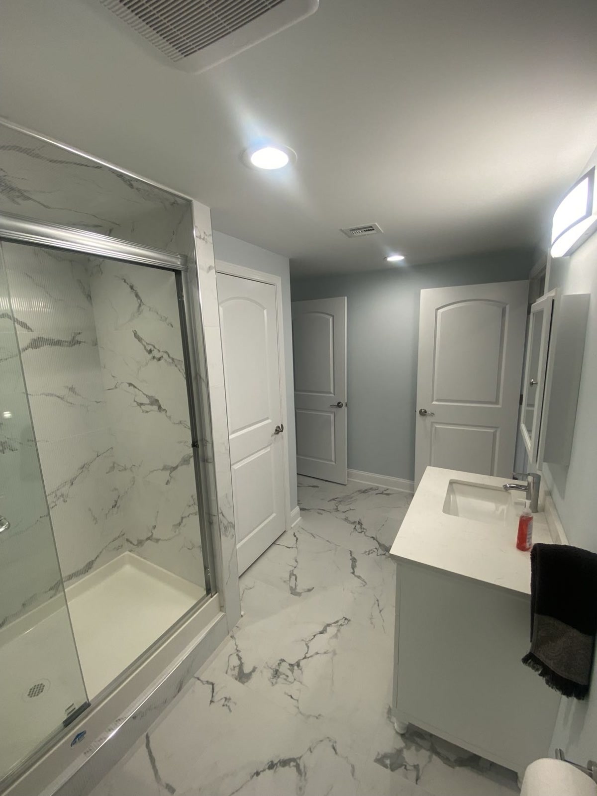 Basement bathroom with marble tile and vanity