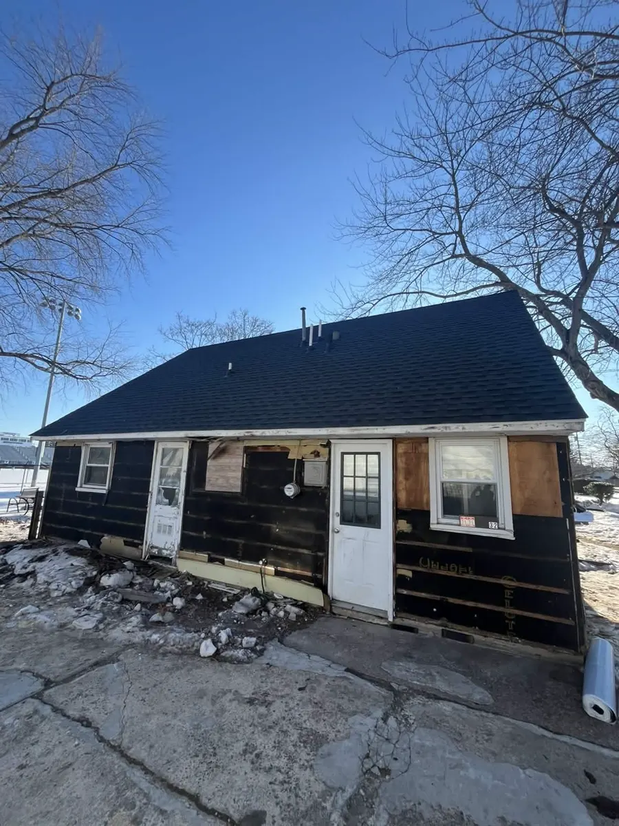Ewing house before exterior completion, with exposed wall surfaces and older windows