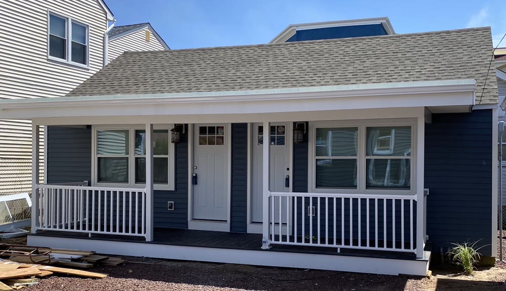 Finished porch with navy siding and white railings