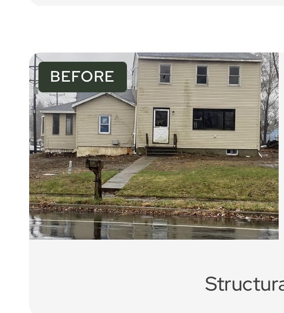 House before renovation - damaged siding, boarded door